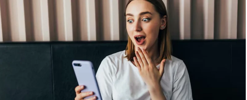 girl checking her phone surprised